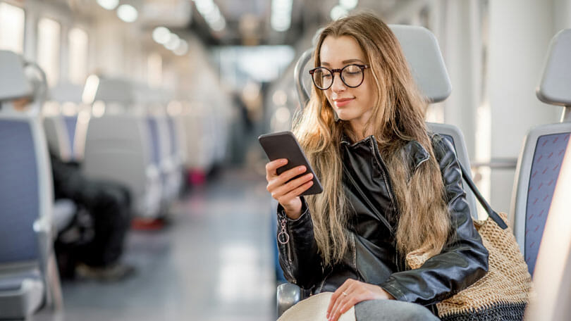 Låna pengar direkt på kontot Låna pengar direkt på kontot - Glad kvinna med mobiltelefon